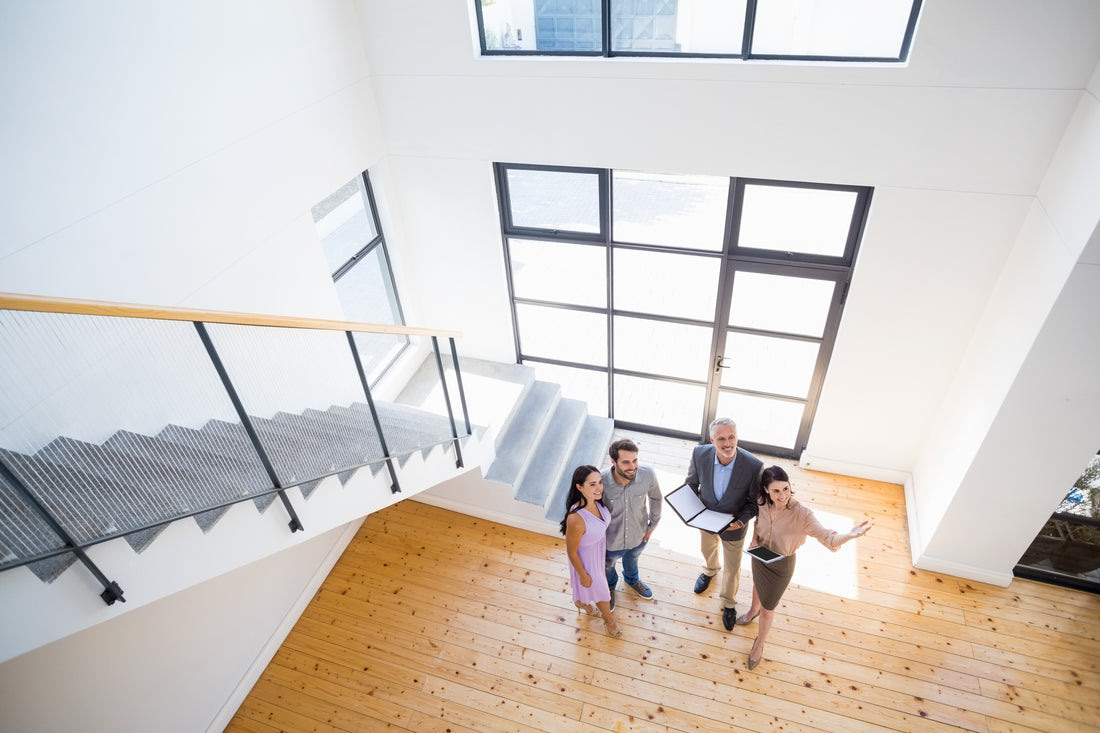 real estate agent showing younger couple a new home